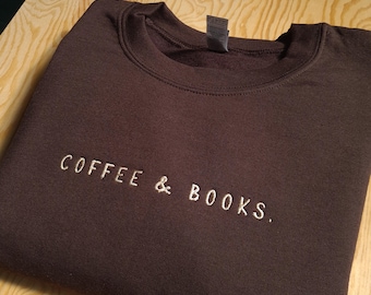 May include: A brown sweatshirt with the text "COFFEE & BOOKS." embroidered in white on the front.
