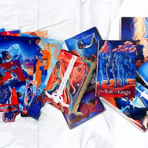 Puede incluir: Una colección de portadas de libros de fantasía con ilustraciones vibrantes. Las portadas presentan personajes, paisajes y texto, con una paleta de colores dominada por azules, rojos y naranjas. Los títulos incluyen "The Way of Kings" y "Rhythm of War".