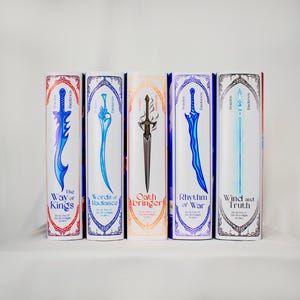 Puede incluir: Cinco libros de tapa dura con lomos blancos, cada uno con un diseño de espada diferente en azul, negro y verde azulado. Los títulos incluyen "The Way of Kings", "Words of Radiance", "Oathbringer", "Rhythm of War" y "Wind and Truth".
