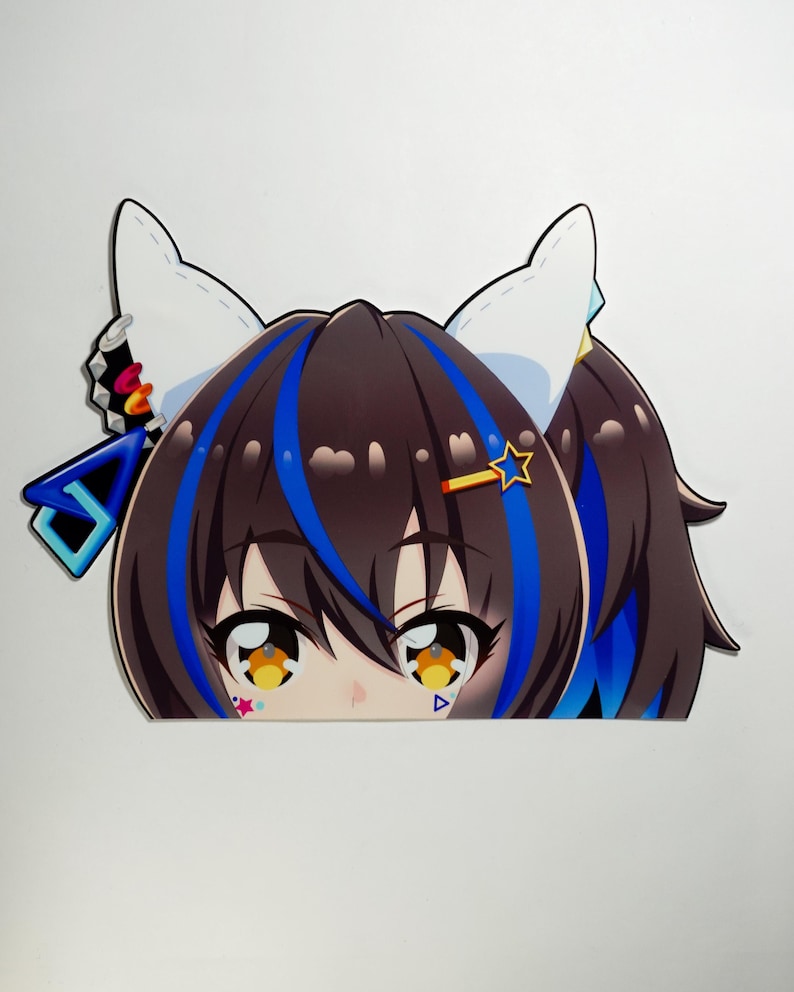 May include: A die-cut sticker featuring a cartoon anime character with brown hair, blue highlights, and cat ears. The character has large, expressive eyes with yellow and orange details, and a star-shaped hair accessory.