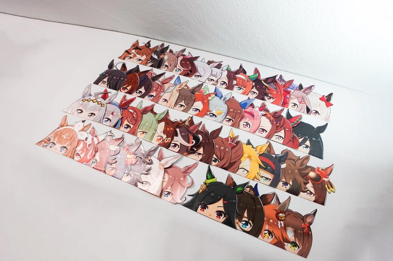 May include: A collection of colorful anime-style character stickers, each featuring a unique design with detailed eyes and hair. The stickers are arranged in rows, showcasing a variety of characters with different color schemes and expressions.