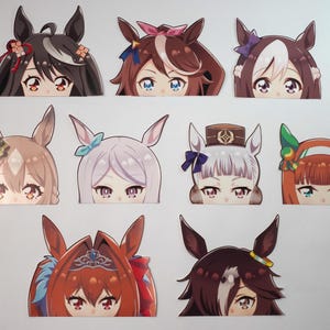 May include: A collection of nine anime-style character cutouts, each featuring a unique hairstyle and eye color. The designs include various hair colors such as black, brown, and red, with decorative elements like bows and headbands.