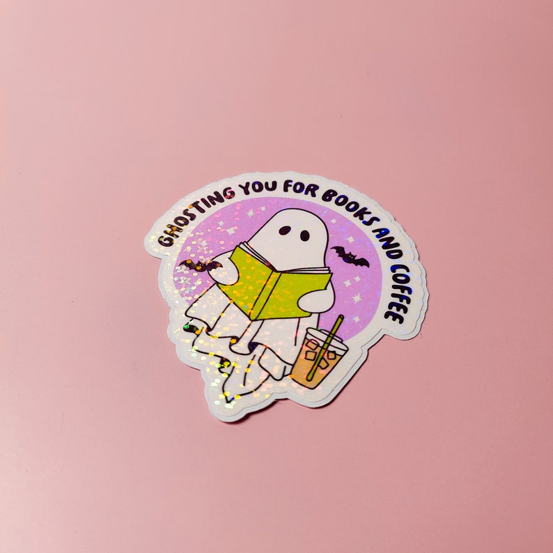 May include: A white ghost with a book and a cup of coffee, with the text "Ghosting you for books and coffee" around it.