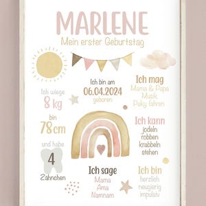 May include: A pink and gold watercolor illustration of a rainbow with a heart in the center. The illustration is surrounded by text in German, including the name "Marlene", "Mein erster Geburtstag", and details about the child's first birthday, such as weight, height, and age.
