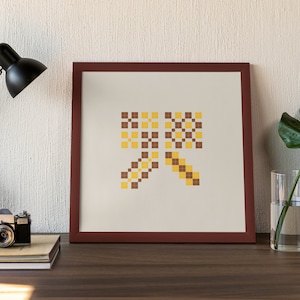 May include: A framed print with a geometric design in shades of brown and yellow. The design is made up of squares arranged in a pattern that resembles a bow.