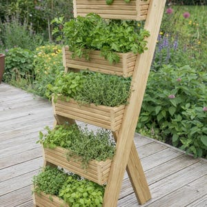 May include: A wooden, multi-tiered planter with various herbs. The planter has a ladder-like design with five rectangular boxes filled with green herbs. The structure is made of light-coloured wood and is set outdoors.