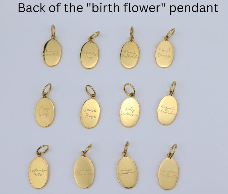 May include: Gold-colored oval pendants with handwritten birth flower names. Each pendant has a small loop at the top for a chain. The text includes names like "March Daffodil" and "April Daisy".