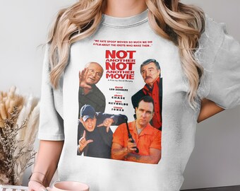 May include: A pale grey t-shirt displaying the movie poster for "Not Another Not Another Movie." The poster features actors and the film's title. The shirt also has the quote "WE HATE SPOOF MOVIES SO MUCH WE DID A FILM ABOUT THE IDIOTS WHO MAKE THEM."