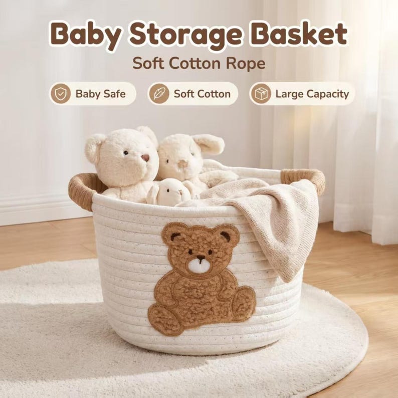 Pode incluir: Um cesto de armazenamento para beb&ecirc;s branco feito de corda de algod&atilde;o macio, com uma aplica&ccedil;&atilde;o de urso de pel&uacute;cia marrom. A cesta cont&eacute;m bichos de pel&uacute;cia e um cobertor. O texto na imagem diz "Baby Storage Basket, Soft Cotton Rope, Baby Safe, Soft Cotton, Large Capacity."