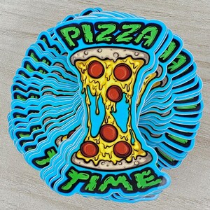 May include: A stack of die-cut stickers featuring a graphic of a slice of pizza with melting yellow cheese and red pepperoni slices. The text PIZZA TIME is written in a green, stylized font above and below the pizza slice on a bright blue background.
