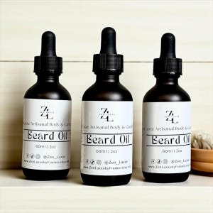 May include: Three black glass bottles of beard oil with white labels. Each bottle has a black dropper and contains 2 oz of product. The labels read "Zen Luxxe Artisanal Body & Candle" and "Beard Oil". The bottles are arranged on a white shelf.