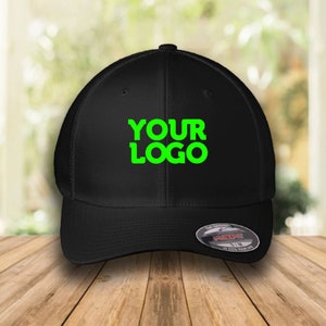 Op de afbeelding: Zwarte baseballpet met een mesh achterkant en een zwart voorpaneel. De pet heeft een groen geborduurd logo met de tekst "YOUR LOGO".