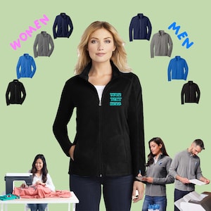 May include: A black fleece jacket with a zipper closure and a stand-up collar. The jacket has a small embroidered design on the left chest that says "YOUR TEXT HERE".