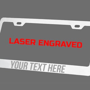May include: A silver license plate frame with a red laser engraved message that says "LASER ENGRAVED" and "YOUR TEXT HERE".