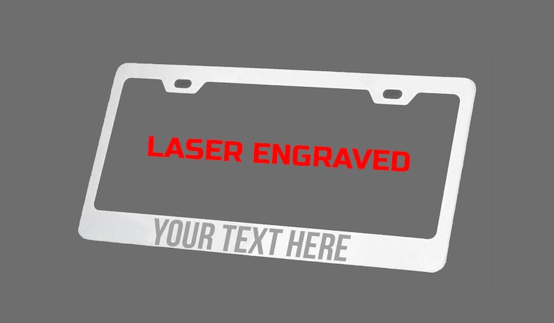 May include: A silver license plate frame with a red laser engraved message that says "LASER ENGRAVED" and "YOUR TEXT HERE".