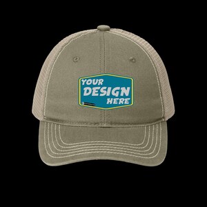 May include: A khaki green and beige trucker hat with a mesh back. The front of the hat has a blue and yellow patch with the text "YOUR DESIGN HERE".