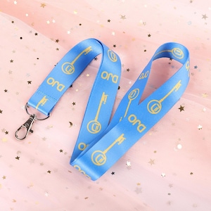 May include: A blue lanyard with a gold key and the word "Ora" printed on it. The lanyard has a metal clip.