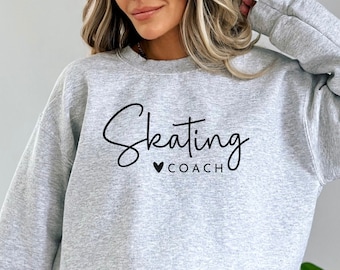 May include: A gray sweatshirt with the text "Skating" in a cursive font and a heart with the word "COACH" below it.