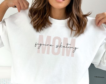 May include: White sweatshirt with the text "MOM figure skating" in pink lettering.