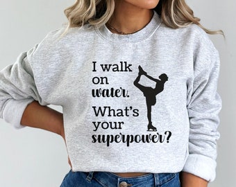 May include: Gray sweatshirt with a black silhouette of a figure ice skating and the text "I walk on water. What's your superpower?"