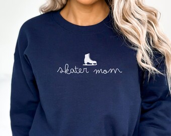 May include: A navy blue sweatshirt with a white ice skate graphic and the text "skater mom" in white.