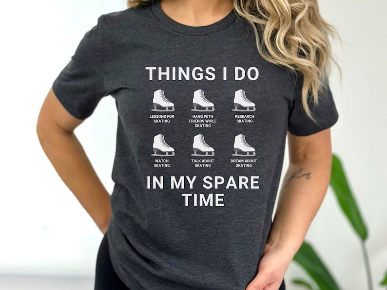 May include: A dark gray t-shirt with the text "THINGS I DO" and a list of ice skating activities, including "LESSONS FOR SKATING", "HANG WITH FRIENDS WHILE SKATING", "RESEARCH SKATING", "WATCH SKATING", "TALK ABOUT SKATING", and "DREAM ABOUT SKATING". The text "IN MY SPARE TIME" is below the list.