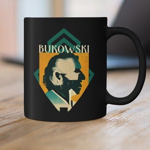 Puede incluir: Taza de cerámica negra con un gráfico blanco de la cara de un hombre y el texto "Bukowski" en estilo retro.