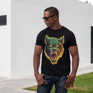 May include: A black t-shirt with a green and yellow wolf graphic print. The wolf has a menacing expression with sharp teeth and glowing eyes.