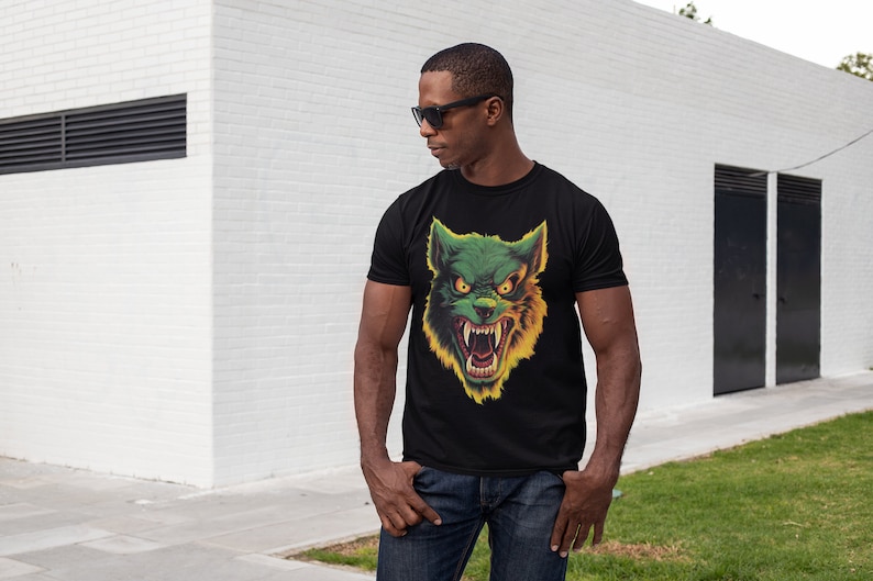 May include: A black t-shirt with a green and yellow wolf graphic print. The wolf has a menacing expression with sharp teeth and glowing eyes.