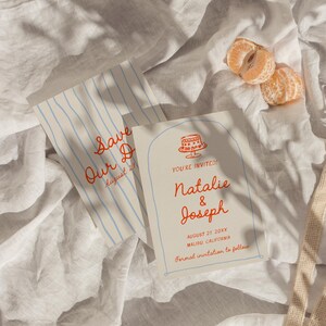May include: Wedding invitation suite featuring a Save the Date card with blue stripes and a main invitation with a cake illustration. The invitations have red text and are on a white background. A beige mesh bag and orange tangerine slices are also in the image.