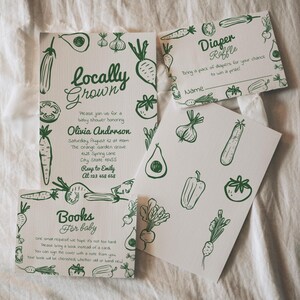 May include: White baby shower invitations with green vegetable illustrations. The main invitation reads "Locally Grown" and includes event details. Other cards include "Diaper Raffle" and "Books for baby".