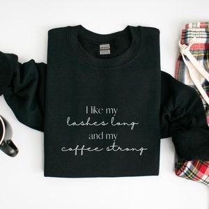 May include: Black sweatshirt with white text that reads "I like my lashes long and my coffee strong".