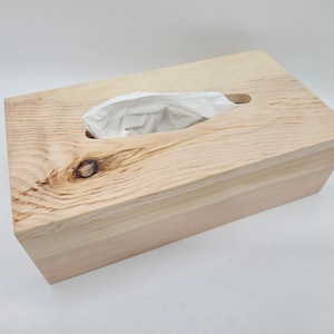 Könnte beinhalten: Ein Holz-Tischtuchbox-Deckel mit natürlicher Holzoptik. Der Deckel hat einen Schlitz für Taschentücher und einen Deckel.