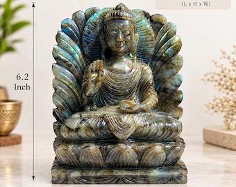 May include: A carved labradorite Buddha statue featuring a seated figure on a lotus base with a radiant halo. The stone displays iridescent blue and gold flashes. The dimensions are clearly marked as 7.2 X 6.2 X 2 inches on the product image.