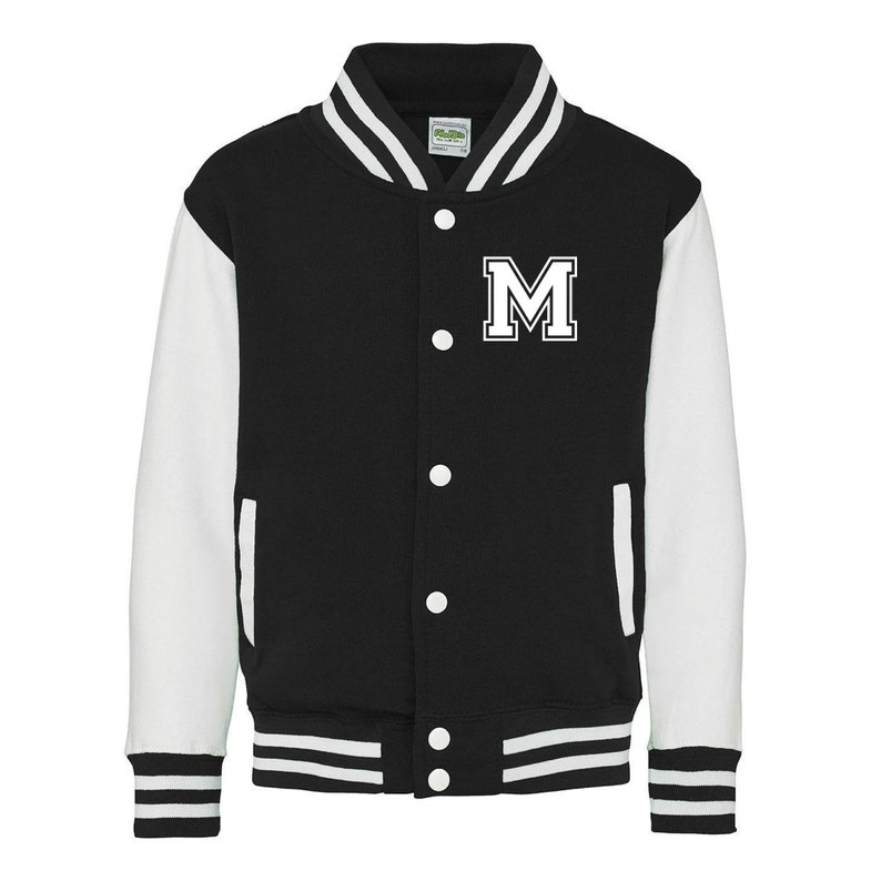 Pu&ograve; includere: Giacca da baseball nera e bianca con una lettera "M" bianca sul davanti. La giacca ha maniche bianche e un corpo nero con strisce bianche sui polsini e sul fondo.