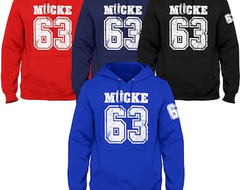 May include: Four hooded sweatshirts in different colours: red, navy blue, black, and royal blue. Each sweatshirt has a white distressed graphic of the name "MÜCKE" and the number "63" on the front.