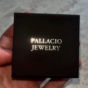 May include: A black jewelry box with the words "PALLACIO JEWELRY" printed in gold lettering.