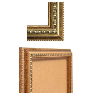 May include: A gold picture frame with a brown wood finish. The frame has a decorative border with gold accents.