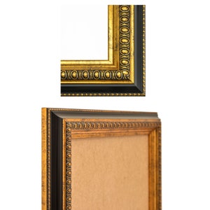 May include: A black and gold picture frame with a decorative border. The frame has a brown cardboard backing.