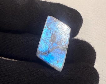 May include: A blue and white iridescent labradorite gemstone with a rough, irregular shape.