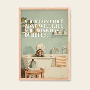 Könnte beinhalten: Gerahmter Druck mit einem Affen in einer Badewanne mit Duschhaube. Das Bild hat eine Vintage-Ästhetik mit dem Text "YOUR COMFORT ZONE WILL KILL YOU. MINE HAS BUBBLES." Ein kleiner Holzschemel trägt eine Teekanne und Bücher.