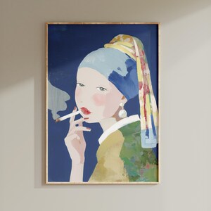Könnte beinhalten: Gerahmter Kunstdruck mit einer Frau mit Perlenohrring, die ein blaues Kopftuch und eine grüne Jacke trägt und eine brennende Zigarette hält. Das Kunstwerk hat einen dunkelblauen Hintergrund und einen goldenen Rahmen.