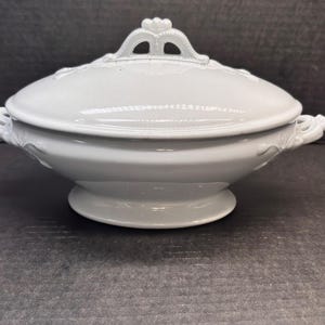 May include: A handmade wooden sign with the text "Welcome" in a playful font. The sign is painted white with a distressed finish, and features a decorative floral design in shades of pink and green. It measures approximately 12 inches wide.