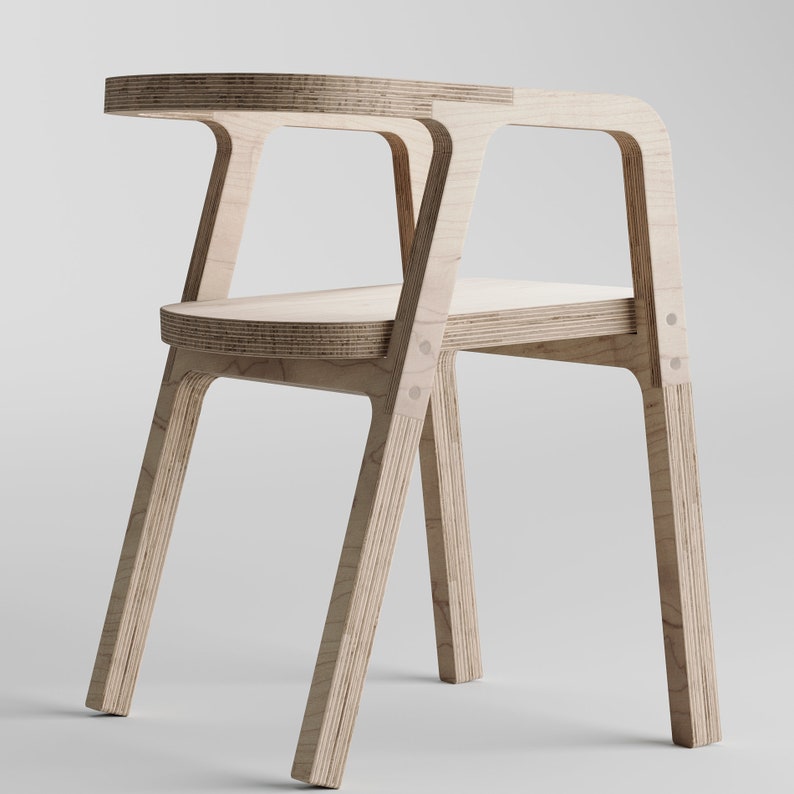 May include: A wooden chair with a simple, modern design. The chair is made of plywood and has a natural wood finish. The chair has a slightly curved back and a wide, comfortable seat.