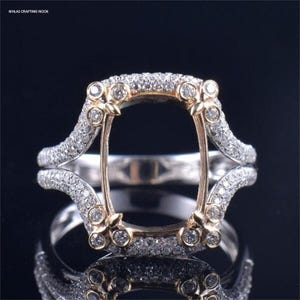 Puede incluir: Un engaste de anillo de oro y plata con un espacio rectangular para una piedra preciosa. El anillo está decorado con pequeños diamantes.