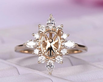 Puede incluir: Un anillo dorado con un engaste central ovalado, rodeado de diamantes talla marquesa y redondos. El diseño del anillo presenta un patrón de rayos de sol, creando una apariencia brillante y elegante. La banda es de oro pulido simple.