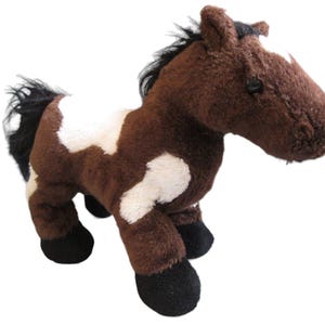 May include: A brown and white plush toy horse with black hooves and a black mane and tail.