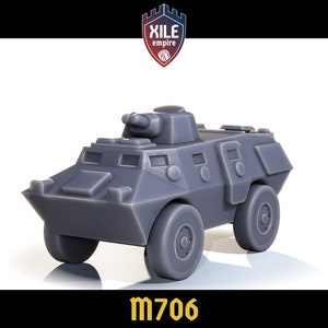 May include: A gray plastic model of a military armored vehicle with a turret and wheels. The vehicle is labeled "M706".
