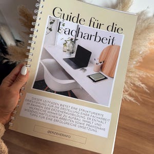 Könnte beinhalten: Ein spiralgebundenes Buch mit dem Titel "Guide für die Facharbeit" in schwarzer Schrift. Das Cover zeigt ein modernes Büro mit Laptop und Schreibtischzubehör. Der Ratgeber bietet eine strukturierte Orientierung für die Erstellung einer Facharbeit.