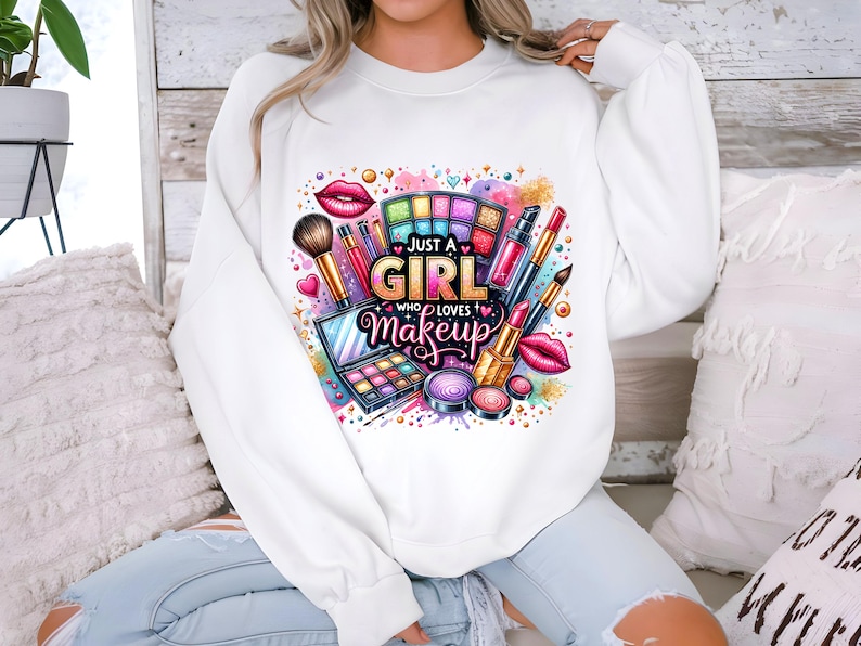 May include: White sweatshirt with a colorful graphic design of makeup items and the text "Just a Girl Who Loves Makeup".